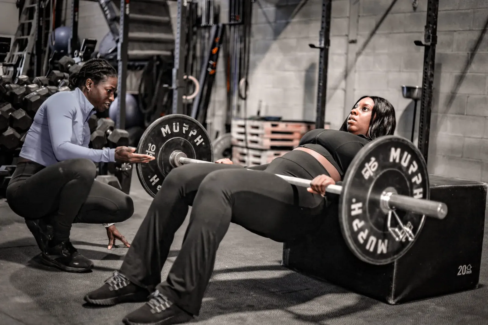 Mivania Henry coaching a client through a barbell hip thrust